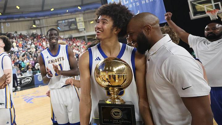 Bremerton head coach Miah Davis and son Jalen enjoy a moment with their first place trophy as the team celebrates on the court after their win over R.A. Long in Yakima on Saturday, March 7, 2026.