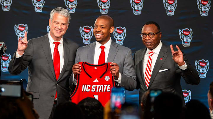 NC State AD Boo Corrigan, men's basketball coach Justin Gainey and Chancellor Kevin Howell pose at Gainey's introductory press conference at the Lenovo Center on Wednesday, April 1, 2026. 