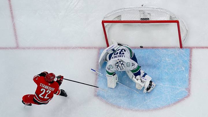 Oct 8, 2026; Raleigh, North Carolina, USA; Carolina Hurricanes center Logan Stankoven (22) scores a goal past Vancouver Canucks goaltender Kevin Lankinen (32) during the second period at Lenovo Center.  Mandatory Credit: James Guillory-Imagn Images