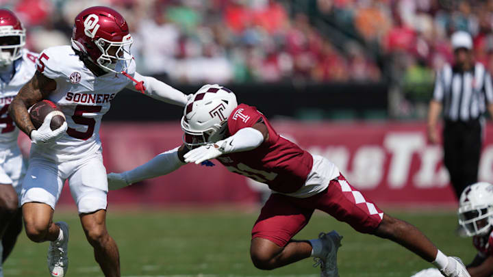 Oklahoma receiver Isaiah Sategna stiff arms a Temple defender.