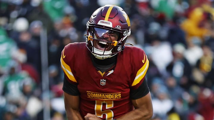 Dec 22, 2024; Landover, Maryland, USA; Washington Commanders quarterback Jayden Daniels (5) celebrates after throwing the game winning touchdown during the fourth quarter against the Philadelphia Eagles at Northwest Stadium. Mandatory Credit: Peter Casey-Imagn Images