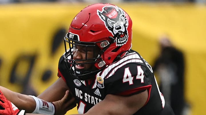 Dec 30, 2022; Charlotte, NC, USA; Maryland Terrapins quarterback Taulia Tagovailoa (3) scrambles as North Carolina State Wolfpack defensive lineman Brandon Cleveland (44) defends in the fourth quarter in the 2022 Duke's Mayo Bowl at Bank of America Stadium. Mandatory Credit: Bob Donnan-Imagn Images