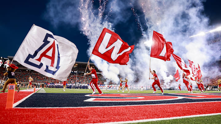 Sep 7, 2024; Tucson, Arizona, USA; Arizona Wildcats cheerleaders runout with flags as they lead the team onto the field before the game against Northern Arizona Lumberjacks at Arizona Stadium