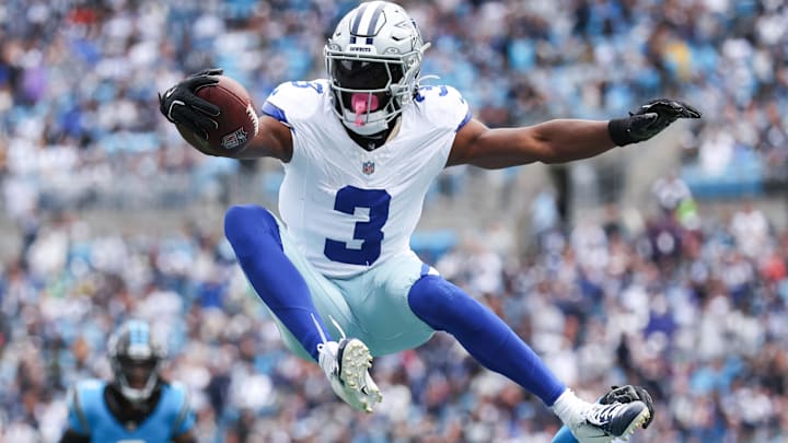 Dallas Cowboys wide receiver George Pickens jumps over Carolina Panthers safety Nick Scott.