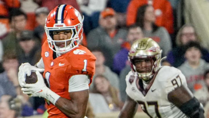 Nov 8, 2025; Clemson, South Carolina, USA; Clemson Tigers wide receiver T.J. Moore (1) runs after a catch near Florida State Seminoles defensive lineman Jayson Jenkins (97) during the second quarter at Memorial Stadium. Mandatory Credit: Ken Ruinard - GREENVILLE NEWS-USA TODAY Network via Imagn Images
