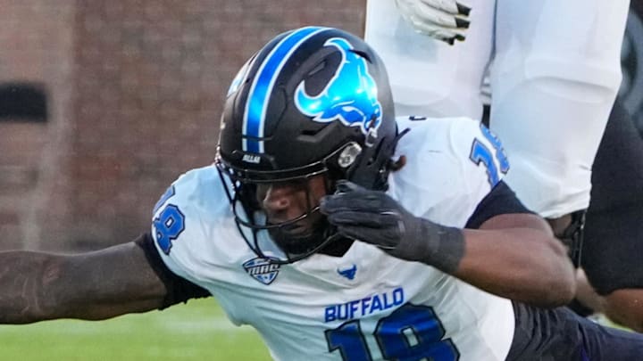 Sep 7, 2024; Columbia, Missouri, USA; Missouri Tigers quarterback Brady Cook (12) leaps over Buffalo Bulls linebacker Dion Crawford (18) and runs in for a touchdown during the first half at Faurot Field at Memorial Stadium.