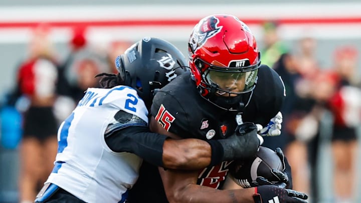 Nov 9, 2024; Raleigh, North Carolina, USA; North Carolina State Wolfpack tight end Justin Joly (15) runs with the ball while Duke Blue Devils safety Jaylen Stinson (2) tackles him during the first half of the game at Carter-Finley Stadium. Mandatory Credit: Jaylynn Nash-Imagn Images
