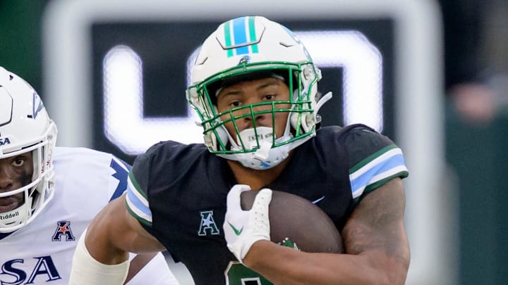Nov 24, 2023; New Orleans, Louisiana, USA; Tulane Green Wave running back Makhi Hughes (21) runs against UTSA Roadrunners running back Kevorian Barnes (4) during the first half at Yulman Stadium. Mandatory Credit: Matthew Hinton-Imagn Images