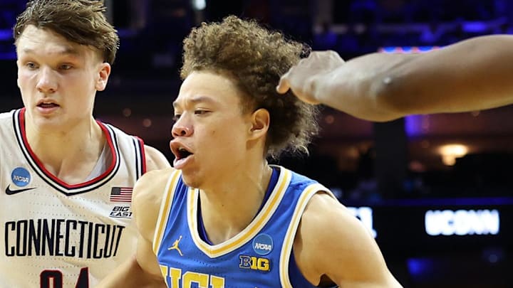 Mar 22, 2026; Philadelphia, PA, USA; UCLA Bruins guard Trent Perry (0) dribbles the ball past UConn Huskies guard Braylon Mullins (24) in the second half during a second round game of the men's 2026 NCAA Tournament at Xfinity Mobile Arena. Mandatory Credit: Bill Streicher-Imagn Images