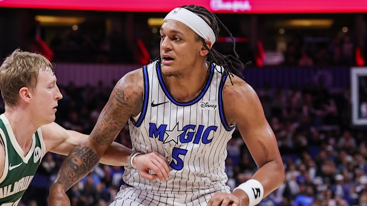 Feb 11, 2026; Orlando, Florida, USA; Orlando Magic forward Paolo Banchero (5) drives against Milwaukee Bucks guard AJ Green (20) during the second half at Kia Center. Mandatory Credit: Mike Watters-Imagn Images