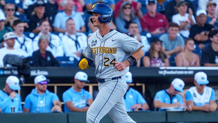 Jun 14, 2026; Omaha, NE, USA; West Virginia Mountaineers right fielder Ben Lumsden (24) runs to home on a single against the West Virginia Mountaineers during the third inning at Charles Schwab Field. Mandatory Credit: Dylan Widger-Imagn Images