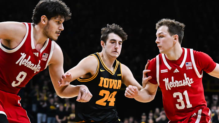 Feb 17, 2026; Iowa City, Iowa, USA; Nebraska Cornhuskers guard Cale Jacobsen (31) controls the ball as Iowa Hawkeyes guard Tate Sage (24) defends and forward Berke Buyuktuncel (9) looks on during the first half at Carver-Hawkeye Arena. Mandatory Credit: Jeffrey Becker-Imagn Images