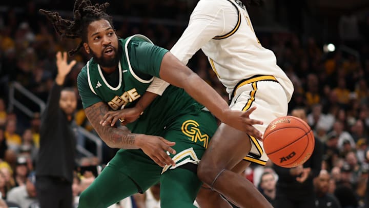Mar 16, 2025; Washington, D.C., USA; George Mason Patriots forward Jalen Haynes (11) passes the ball as VCU Rams forward Christian Fermin (21) defends in the first half at Capital One Arena. Mandatory Credit: Geoff Burke-Imagn Images