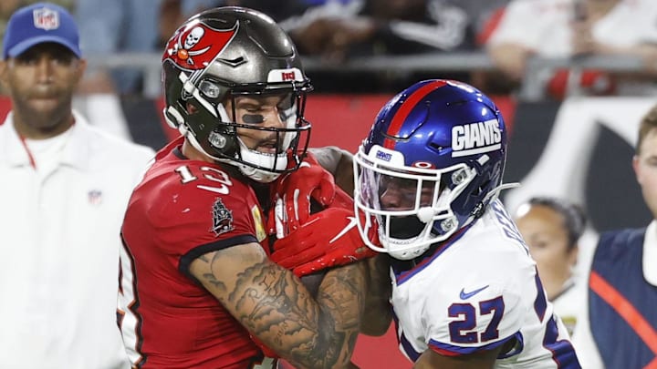 Nov 22, 2021; Tampa, Florida, USA; Tampa Bay Buccaneers wide receiver Mike Evans (13) runs with the ball as New York Giants safety J.R. Reed (27) defends during the second quarter at Raymond James Stadium. Mandatory Credit: Kim Klement-Imagn Images