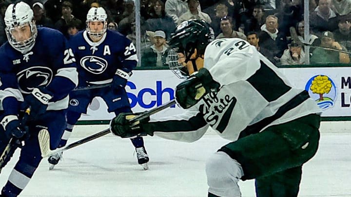 Michigan State's Porter Martone (22) shoots the puck past defenders and Penn State goaltender Josh Fleming (34) late in the first period at Munn Ice Arena Saturday, Nov. 8, 2025. Michigan State's Porter Martone (22) shoots the puck past defenders and Penn State goaltender Josh Fleming (34) late in the first period at Munn Ice Arena Saturday, Nov. 8, 2025.