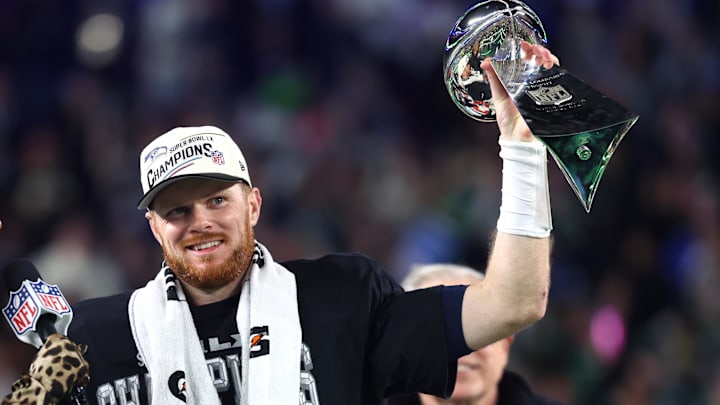 Feb 8, 2026; Santa Clara, CA, USA; Seattle Seahawks quarterback Sam Darnold (14) celebrates with the Vince Lombardi trophy on the podium after defeating the New England Patriots in Super Bowl LX at Levi's Stadium. Mandatory Credit: Mark J. Rebilas-Imagn Images