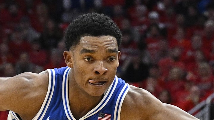 Jan 6, 2026; Louisville, Kentucky, USA;  Louisville Cardinals guard Adrian Wooley (14) dribbles against Duke Blue Devils guard Caleb Foster (1) during the second half at KFC Yum! Center. Duke defeated Louisville 84-73. Mandatory Credit: Jamie Rhodes-Imagn Images