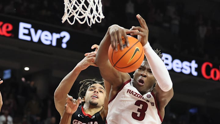 Arkansas Razorbacks forward Adou Thiero (3) grabs a rebound in front of Georgia Bulldogs freshman forward Asa Newell (14) during the second half at Bud Walton Arena on Wednesday. The Hogs won the board battle by 10 and topped Georgia 68-65 for their first SEC victory.