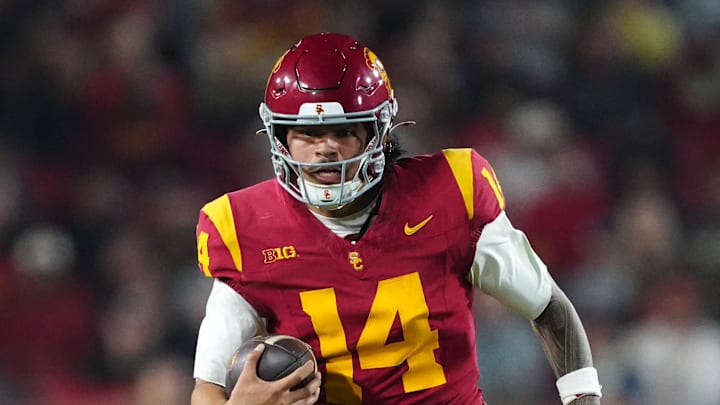 Nov 29, 2025; Los Angeles, California, USA; Southern California Trojans quarterback Jayden Maiava (14) carries the ball against the UCLA Bruins in the first half at United Airlines Field at Los Angeles Memorial Coliseum. Mandatory Credit: Kirby Lee-Imagn Images