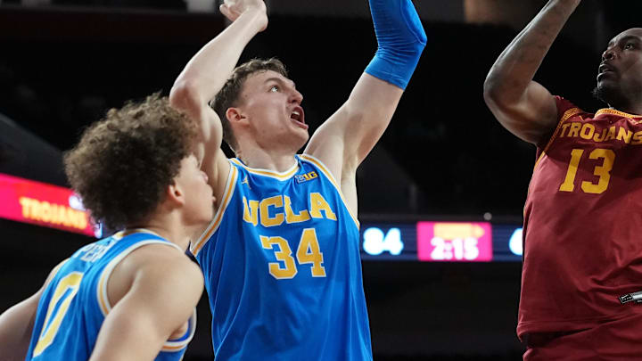 Mar 7, 2026; Los Angeles, California, USA; Southern California Trojans guard Kam Woods (13) shoots the ball against UCLA Bruins guard Trent Perry (0), forward Tyler Bilodeau (34) and forward Eric Dailey Jr. (3) in the second half at Galen Center. Mandatory Credit: Kirby Lee-Imagn Images