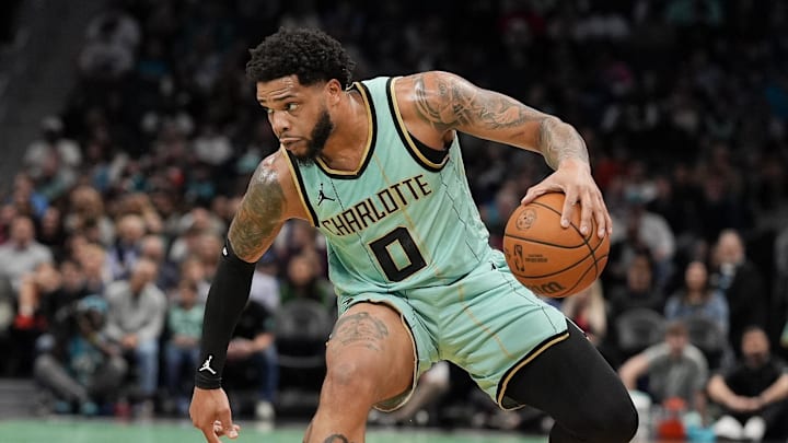 Feb 7, 2025; Charlotte, North Carolina, USA; Charlotte Hornets forward Miles Bridges (0) handles the ball defended by San Antonio Spurs forward Julian Champagnie (30) during the first quarter at Spectrum Center. Mandatory Credit: Jim Dedmon-Imagn Images