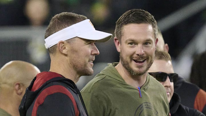 Nov 11, 2023; Eugene, Oregon, USA; USC Trojans head coach Lincoln Riley, left, and Oregon Ducks head coach Dan Lanning talk before a game at Autzen Stadium. Mandatory Credit: Troy Wayrynen-Imagn Images Nov 11, 2023; Eugene, Oregon, USA; USC Trojans head coach Lincoln Riley, left, and Oregon Ducks head coach Dan Lanning talk before a game at Autzen Stadium. Mandatory Credit: Troy Wayrynen-Imagn Images