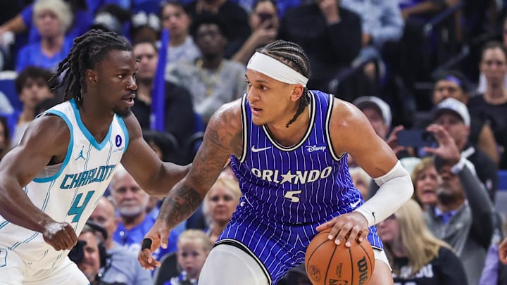 Apr 17, 2026; Orlando, Florida, USA; Charlotte Hornets guard Sion James (4) defends Orlando Magic forward Paolo Banchero (5) during the second half during the play-in rounds of the 2026 NBA Playoffs at Kia Center. Mandatory Credit: Mike Watters-Imagn Images