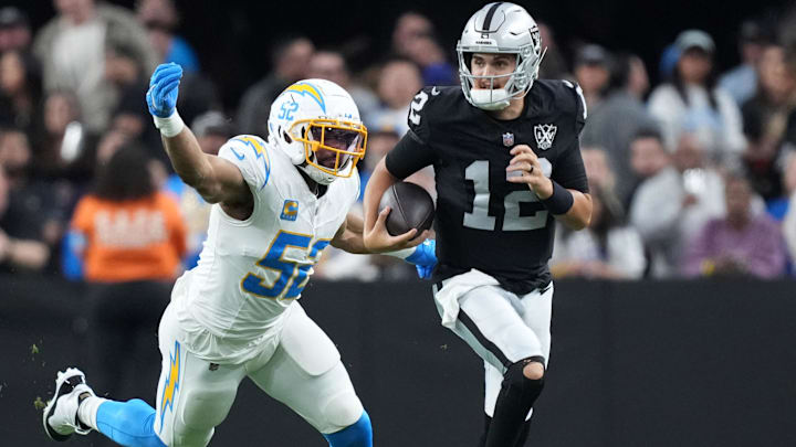 Jan 5, 2025; Paradise, Nevada, USA; Las Vegas Raiders quarterback Aidan O'Connell (12) carries the ball against Los Angeles Chargers linebacker Khalil Mack (52) in the second half at Allegiant Stadium. Mandatory Credit: Kirby Lee-Imagn Images