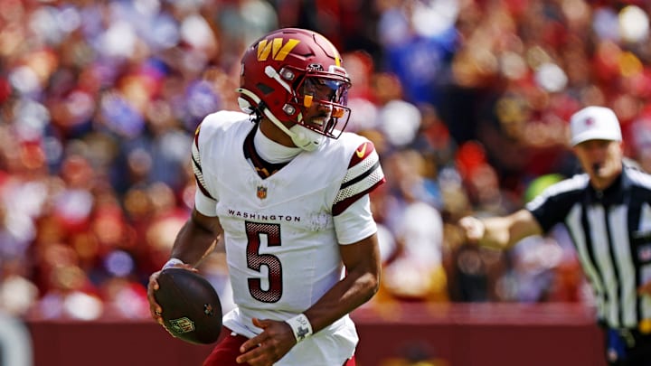 Sep 7, 2025; Landover, Maryland, USA; Washington Commanders quarterback Jayden Daniels (5) runs the ball against New York Giants linebacker Brian Burns (0) during the second quarter at Northwest Stadium. Mandatory Credit: Peter Casey-Imagn Images
