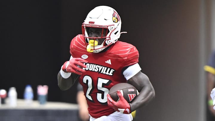 Aug 31, 2024; Louisville, Kentucky, USA; Louisville Cardinals running back Isaac Brown (25) runs the ball against Austin Peay Governors defensive back Cinque Williams (4) during the second quarter at L&N Federal Credit Union Stadium. Louisville defeated Austin Peay 62-0. Mandatory Credit: Jamie Rhodes-Imagn Images Aug 31, 2024; Louisville, Kentucky, USA; Louisville Cardinals running back Isaac Brown (25) runs the ball against Austin Peay Governors defensive back Cinque Williams (4) during the second quarter at L&N Federal Credit Union Stadium. Louisville defeated Austin Peay 62-0. Mandatory Credit: Jamie Rhodes-Imagn Images