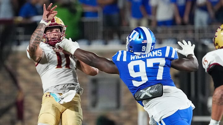 Aug 28, 2025; Durham, North Carolina, USA; Elon Phoenix quarterback Landen Clark (11) is hit by Duke Blue Devils defensive end Wesley Williams (97) on his pass during the second half at Wallace Wade Stadium. Mandatory Credit: James Guillory-Imagn Images