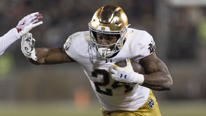 Nov 29, 2025; Stanford, California, USA;  Notre Dame Fighting Irish running back Jadarian Price (24) runs with the football against Stanford Cardinal safety Darrius Davis (29) during the first quarter at Stanford Stadium. 