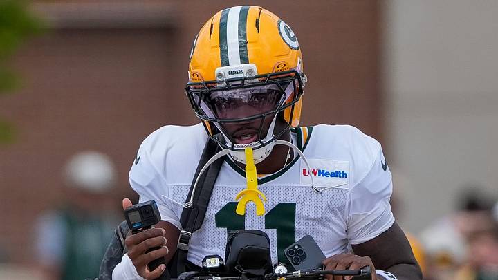 Green Bay Packers wide receiver Jayden Reed (11) rides a bicycle to a joint practice with the Arizona Cardinals. Green Bay Packers wide receiver Jayden Reed (11) rides a bicycle to a joint practice with the Arizona Cardinals.