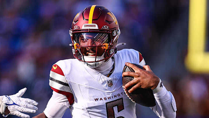 Nov 3, 2024; East Rutherford, New Jersey, USA; Washington Commanders quarterback Jayden Daniels (5) scrambles away from New York Giants linebacker Micah McFadden (41) during the first half at MetLife Stadium. Mandatory Credit: Vincent Carchietta-Imagn Images