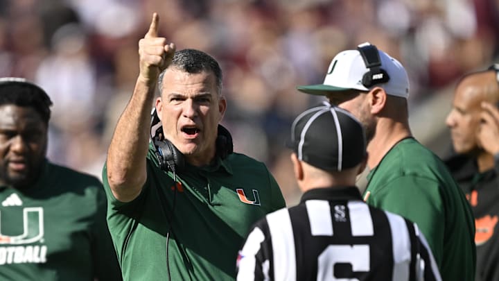 Dec 20, 2025; College Station, TX, USA; Miami Hurricanes head coach Mario Cristobal talks with an official during the second half of the first round game of the CFP National Playoff against the Texas A&M Aggies at Kyle Field. Mandatory Credit: Jerome Miron-Imagn Images Dec 20, 2025; College Station, TX, USA; Miami Hurricanes head coach Mario Cristobal talks with an official during the second half of the first round game of the CFP National Playoff against the Texas A&M Aggies at Kyle Field. Mandatory Credit: Jerome Miron-Imagn Images
