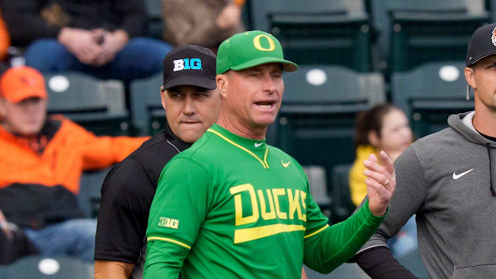 Oregon head coach Mark Wasikowski, second from left, and Oregon State head coach Mitch Canham, third from left, meet with umpires before the game as the Oregon Ducks host the Oregon State Beavers on March 3, 2026, at PK Park in Eugene, Oregon.