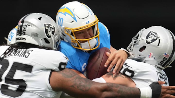 Sep 8, 2024; Inglewood, California, USA; Los Angeles Chargers quarterback Justin Herbert (10) is tackled by Las Vegas Raiders defensive tackle John Jenkins (95) and defensive end Maxx Crosby (98) in the first half at SoFi Stadium. Mandatory Credit: Kirby Lee-Imagn Images Sep 8, 2024; Inglewood, California, USA; Los Angeles Chargers quarterback Justin Herbert (10) is tackled by Las Vegas Raiders defensive tackle John Jenkins (95) and defensive end Maxx Crosby (98) in the first half at SoFi Stadium. Mandatory Credit: Kirby Lee-Imagn Images