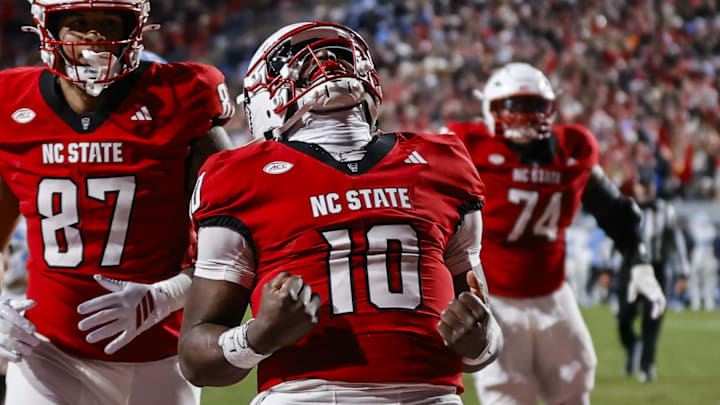 Nov 29, 2025; Raleigh, North Carolina, USA;  NC State Wolfpack quarterback Will Wilson (10) makes a touchdown and celebrates during the first half of the game against North Carolina Tar Heels at Carter-Finley Stadium.  Mandatory Credit: Jaylynn Nash-Imagn Images