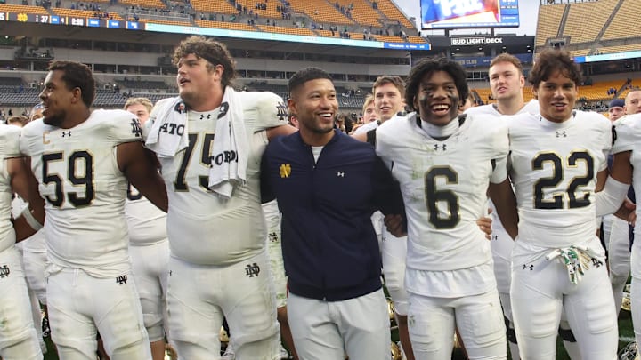 Nov 15, 2025; Pittsburgh, Pennsylvania, USA;  Notre Dame Fighting Irish head coach Marcus Freeman (middle) joins his players in singing the victory song after defeating the Pittsburgh Panthers at Acrisure Stadium. 