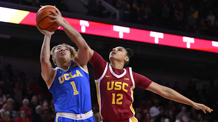 Feb 13, 2025; Los Angeles, California, USA; UCLA Bruins guard Kiki Rice (1) drives to the basket against USC Trojans guard JuJu Watkins (12) during the first quarter at Galen Center. 