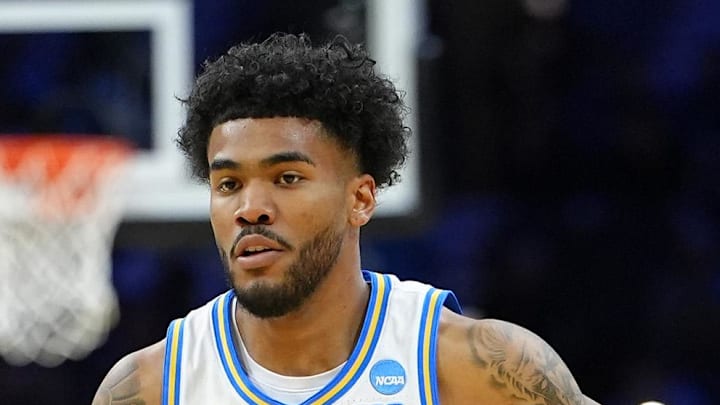 Mar 20, 2026; Philadelphia, PA, USA; UCLA Bruins guard Donovan Dent (2) dribbles the ball past UCF Knights forward Jordan Burks (99) in the first half during a first round game of the men's 2026 NCAA Tournament at Xfinity Mobile Arena. Mandatory Credit: Kyle Ross-Imagn Images