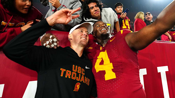 Nov 29, 2025; Los Angeles, California, USA; Southern California Trojans head coach Lincoln Riley (right) and defensive tackle Jahkeem Stewart (4) pose with fans after the game against the UCLA Bruins at United Airlines Field at Los Angeles Memorial Coliseum. Mandatory Credit: Kirby Lee-Imagn Images Nov 29, 2025; Los Angeles, California, USA; Southern California Trojans head coach Lincoln Riley (right) and defensive tackle Jahkeem Stewart (4) pose with fans after the game against the UCLA Bruins at United Airlines Field at Los Angeles Memorial Coliseum. Mandatory Credit: Kirby Lee-Imagn Images
