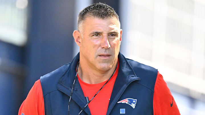 Jul 23, 2025; Foxborough, MA, USA; New England Patriots head coach Mike Vrabel delivers a puppy to a local family as part of the Patriots pet adoption event before the start of training camp at Gillette Stadium. Mandatory Credit: Eric Canha-Imagn Images