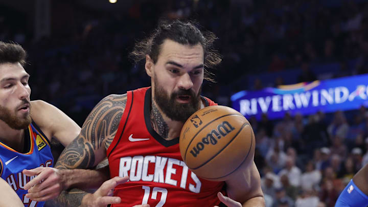 Oct 21, 2025; Oklahoma City, Oklahoma, USA; Houston Rockets center Steven Adams (12) and Oklahoma City Thunder center Chet Holmgren (7) reach for a loose ball during the second half at Paycom Center. Mandatory Credit: Alonzo Adams-Imagn Images