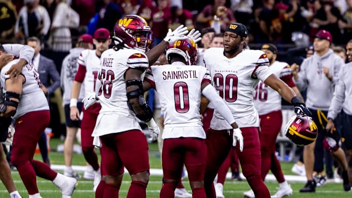 Dec 15, 2024; New Orleans, Louisiana, USA;  Washington Commanders cornerback Mike Sainristil (0) and defensive end Javontae Jean-Baptiste (90) celebrate a New Orleans Saints failed attempt on a two point conversion as time expires at Caesars Superdome. Mandatory Credit: Stephen Lew-Imagn Images