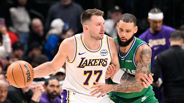 Jan 24, 2026; Dallas, Texas, USA; Los Angeles Lakers guard Luka Doncic (77) looks to move the ball past Dallas Mavericks forward Caleb Martin (16) during the first quarter at the American Airlines Center. Mandatory Credit: Jerome Miron-Imagn Images