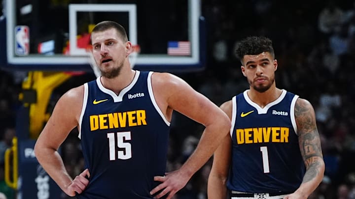 Nov 6, 2024; Denver, Colorado, USA; Denver Nuggets center Nikola Jokic (15) and Denver Nuggets forward Michael Porter Jr. (1)  during a time out ihe first quarter against the Oklahoma City Thunder at Ball Arena. Mandatory Credit: Ron Chenoy-Imagn Images