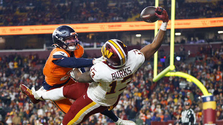 Nov 30, 2025; Landover, Maryland, USA; Washington Commanders wide receiver Treylon Burks (13) makes a catch for a touchdown defended by Denver Broncos cornerback Riley Moss (21) in the third quarter of the game at Northwest Stadium. Mandatory Credit: Peter Casey-Imagn Images