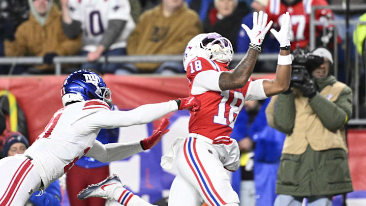 Dec 1, 2025; Foxborough, Massachusetts, USA; New England Patriots wide receiver Kyle Williams (18) catches a pass for a touchdown against New York Giants cornerback Paulson Adebo (21) during the second quarter at Gillette Stadium. Mandatory Credit: Eric Canha-Imagn Images