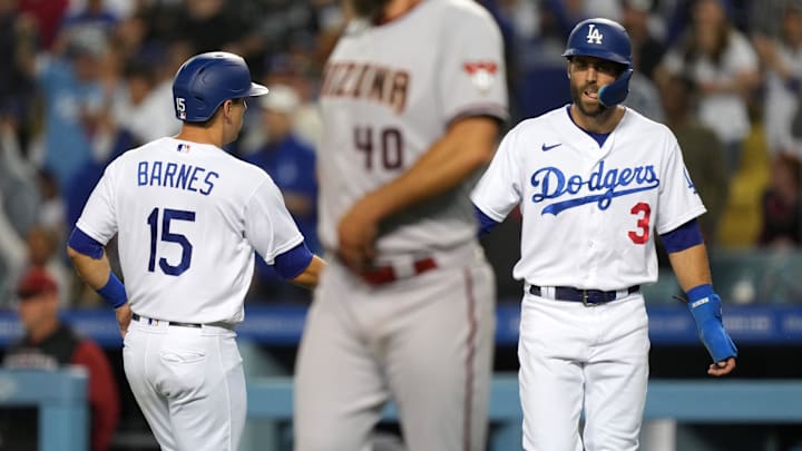 Dodgers catcher Austin Barnes (15) celebrates with designated hitter Chris Taylor (3) after scoring in the fifth inning as Arizona Diamondbacks starting pitcher Madison Bumgarner (40) reacts at Dodger Stadium in May 2022.